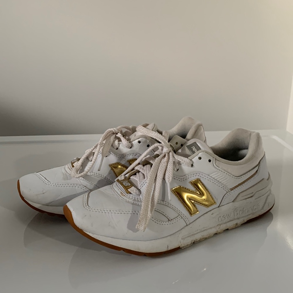 White, gold, silver New Balance sneakers.